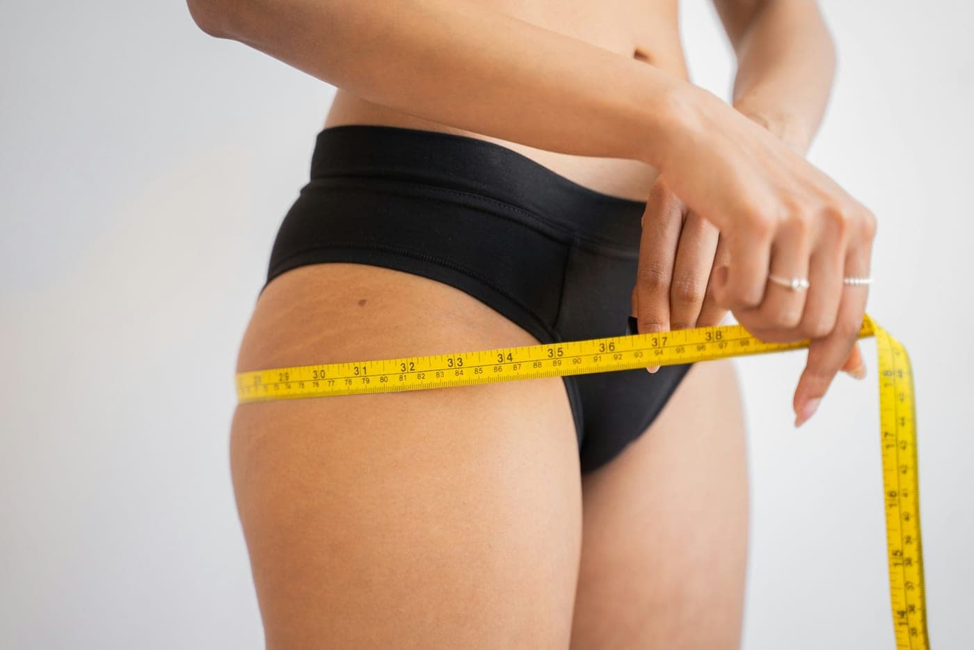 Measuring tape around the hip, showing an area targeted by fat-dissolving treatment